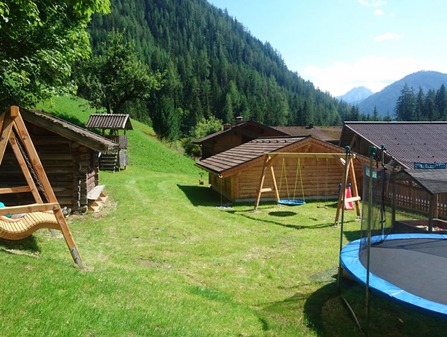 Kinderspielplatz mit Trampolin, Rutsche und Schaukel